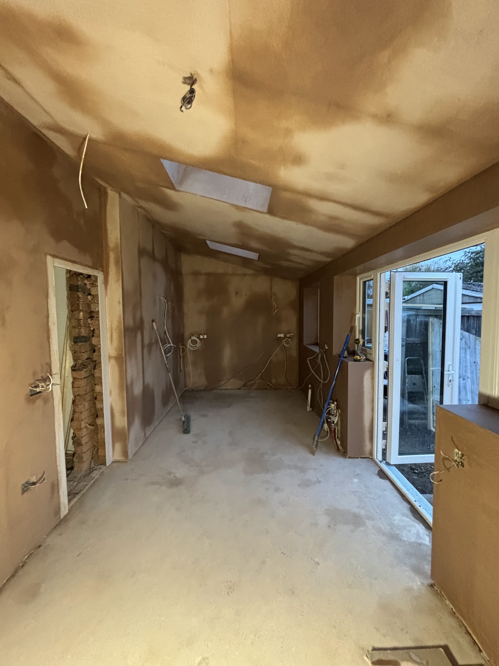 A long extension freshly skimmed by LRW Plastering, with two rooflights and patio doors