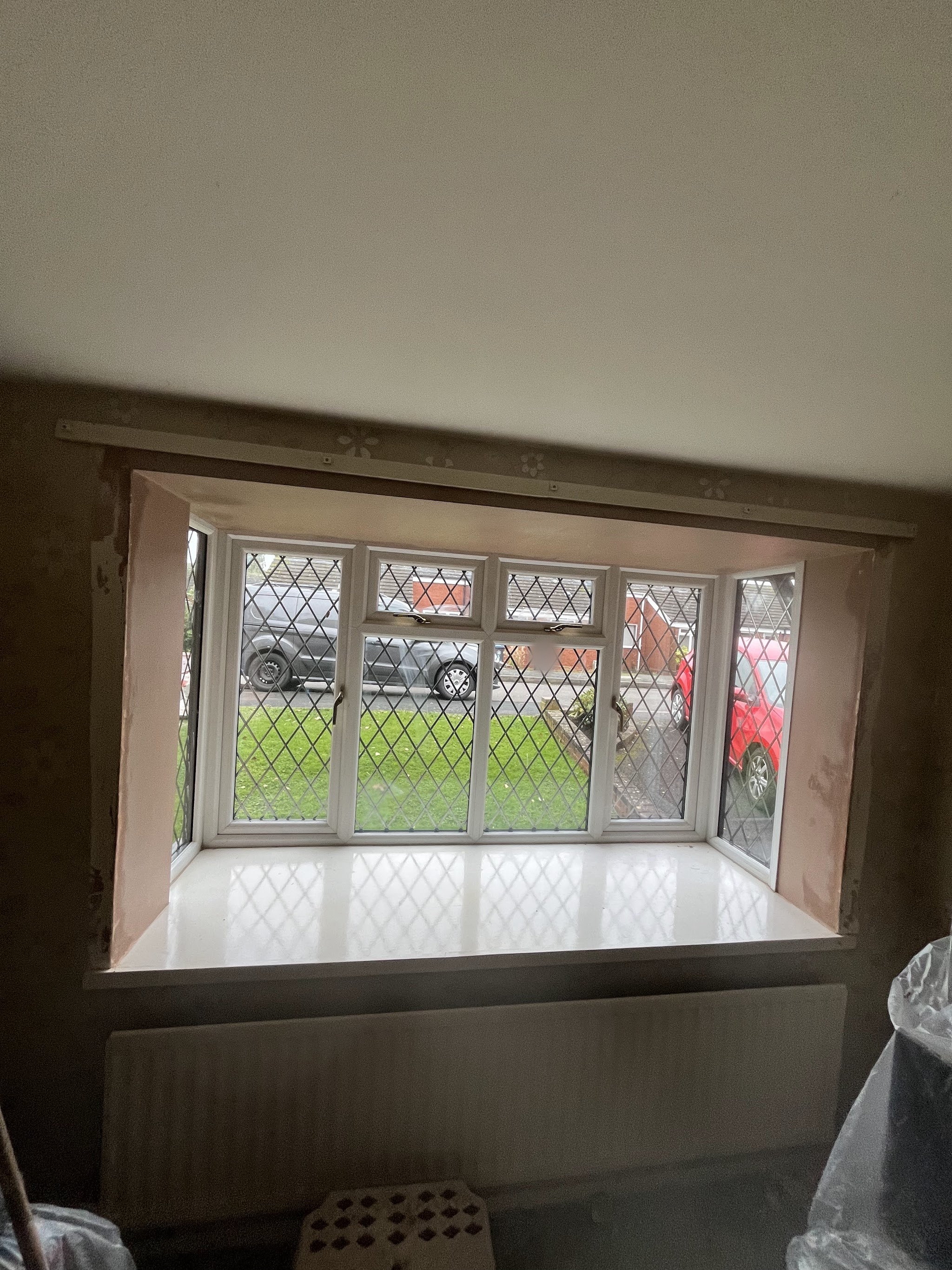A bay window with freshly plastered reveals and walls and a new white sill