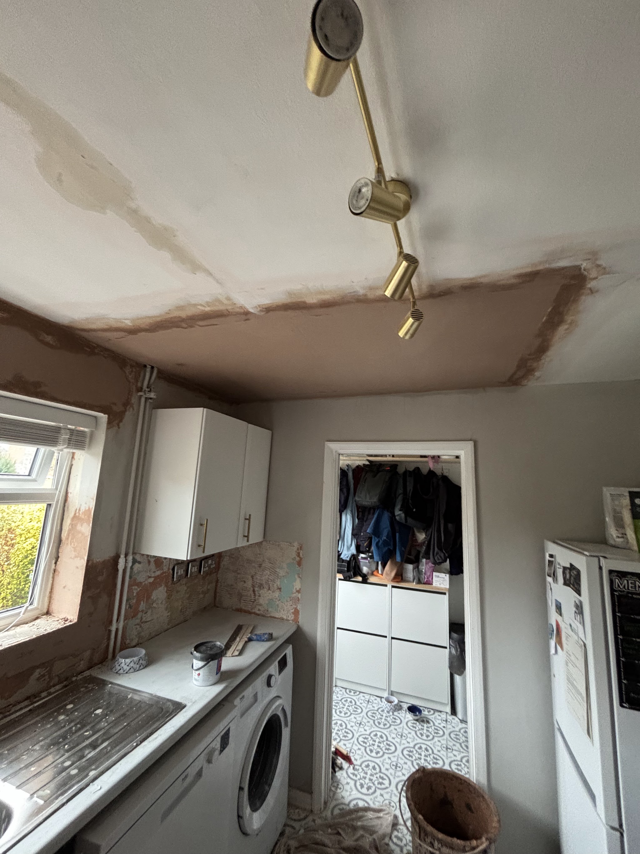 A kitchen ceiling with a freshly skimmed section around the spotlight track