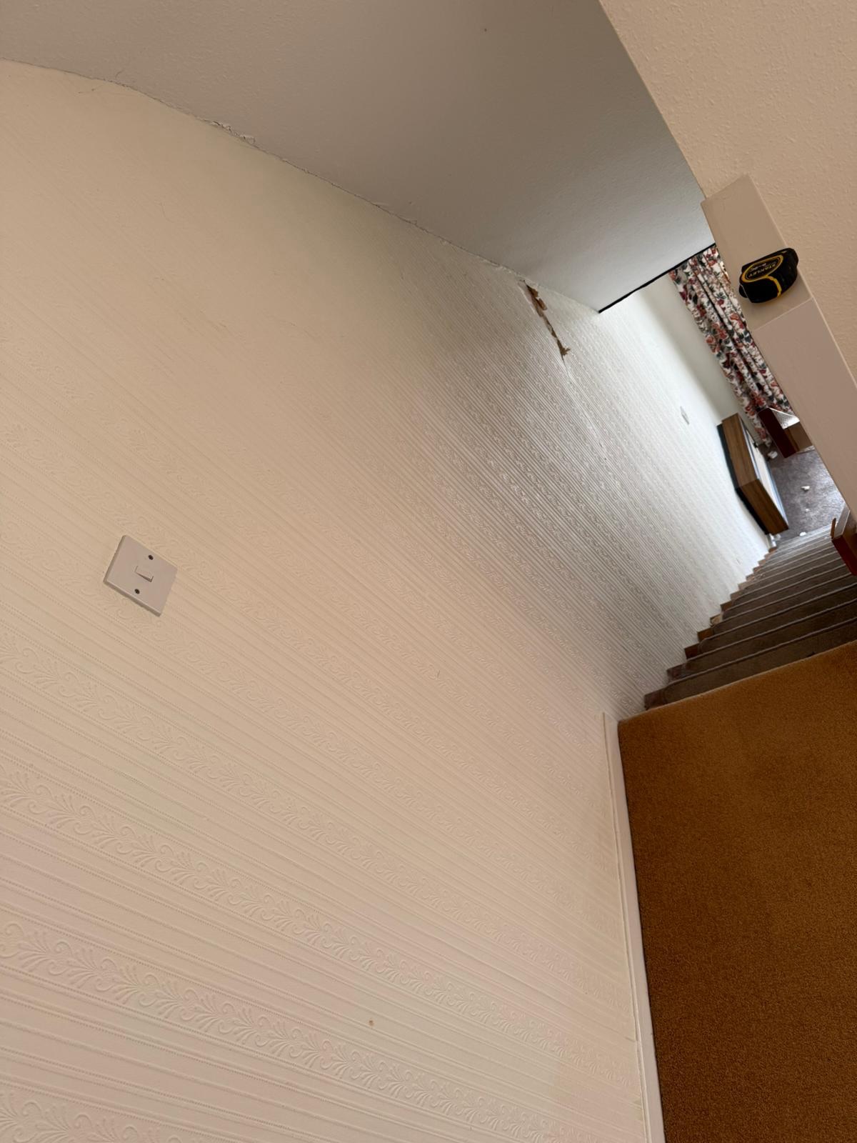 The stair area of a house in Wythall during the crack repair, with the papered wall kept in place